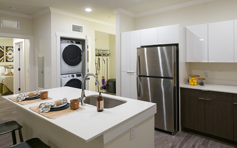 Kitchen with a refrigerator, washer, dryer, and an island.